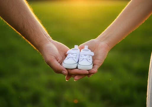 Parents holding tiny baby shoes in their hands