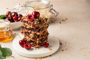 Stack of baked oatmeal crumble squares with fresh cherry. Cherry oatmeal crumble bars. Quick and easy homemade red berry pie with streusel. Crumble fruit cake. Home cooking. Copy space.