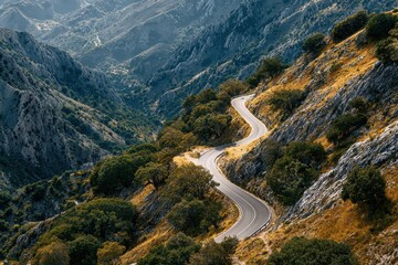 Winding mountain road offers breathtaking views of rugged terrain and scenic landscapes during a clear day in the countryside