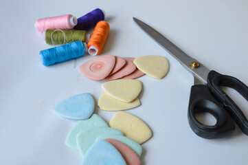 colorful sewing supplies including spools of thread tailor’s chalk scissors arranged on a white surface tailoring handmade fashion, sewing tools, dressmaking creative hobbies