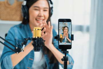 Host channel Asian influencer talking in broadcast wearing headsets on social media live on...