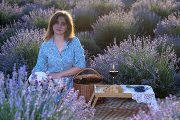 Young woman kneeling in lavender field touching flowers