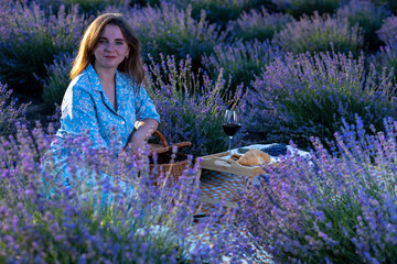 Young woman kneeling in lavender field touching flowers