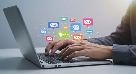 Person typing on laptop with colorful email icons floating above the keyboard in a digital space