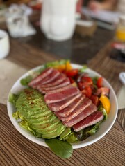 Fresh Tuna Salad with Avocado and Cherry Tomatoes on Wooden Table