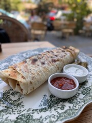 Grilled Wrap Served with Sauces and Pickles on Elegant Plate