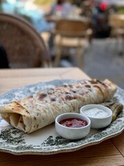 Grilled Wrap Served with Sauces and Pickles on Elegant Plate