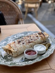 Grilled Wrap Served with Sauces and Pickles on Elegant Plate