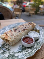 Grilled Wrap Served with Sauces and Pickles on Elegant Plate