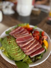 Fresh Tuna Salad with Avocado and Cherry Tomatoes on Wooden Table