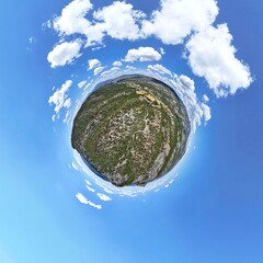 Asarlik Hills Natural Monument Miniature landscape panorama of a lush green island under a vibrant blue sky.A captivating miniature-world-style image showcasing a small, verdant island with a mix of 
