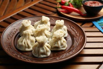 Delicious khinkali served on wooden table, closeup