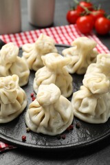 Delicious khinkali served on black table, closeup