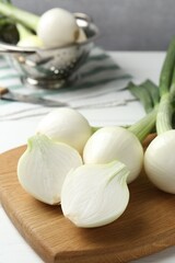 Fresh ripe green onions on white wooden table, closeup