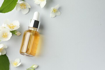 Cosmetic product and jasmine flowers on light background, flat lay. Space for text