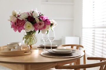 Beautiful table setting with bouquet of peonies in dining room. Space for text