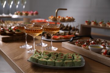 Buffet menu. Glasses of sparkling wine and tasty appetizers on table, closeup