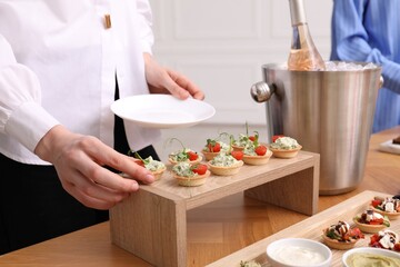 Buffet menu. Woman taking tasty tartlet from table, closeup