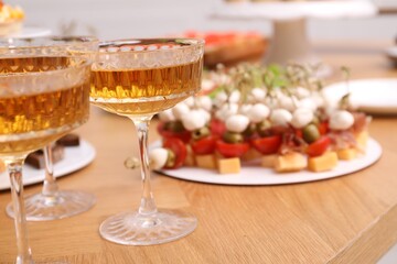 Buffet menu. Glasses of sparkling wine and tasty appetizers on table, closeup