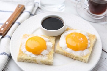 Tasty kaya toasts with half-boiled eggs served on white wooden table, closeup. Traditional asian breakfast