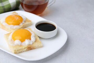 Traditional asian breakfast with tasty kaya toasts and half-boiled eggs served on light grey table, closeup. Space for text