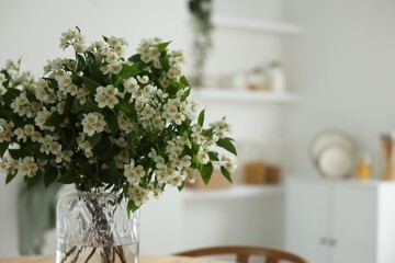 Bouquet of beautiful jasmine flowers in vase indoors, closeup. Space for text