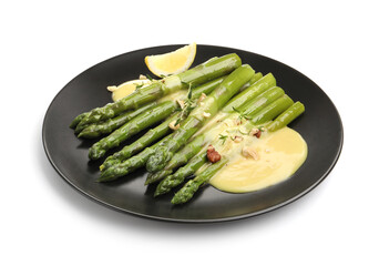 Tasty cooked asparagus with lemon and sauce isolated on white