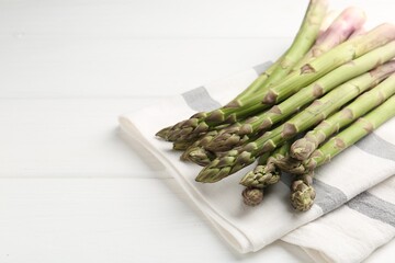 Fresh raw asparagus spears on white wooden table, closeup