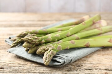 Fresh raw asparagus spears on wooden table, closeup