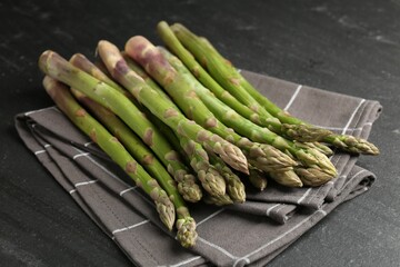 Fresh raw asparagus spears on black table, closeup