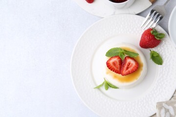 Tasty panna cotta with caramel, strawberries and mint on light table, flat lay. Space for text