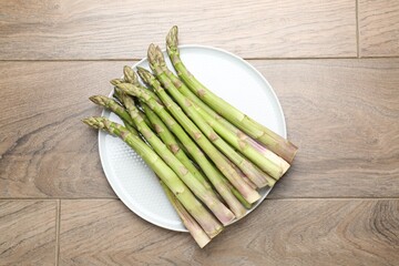 Fresh raw asparagus on wooden table, top view