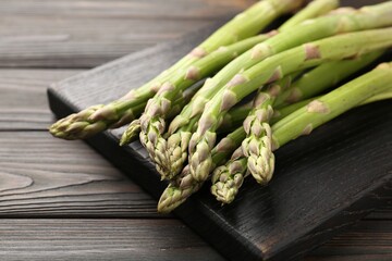 Fresh raw asparagus on black wooden table, closeup