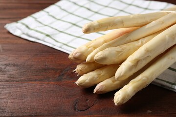 Raw asparagus spears on wooden table, closeup. Space for text