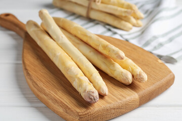 Raw asparagus spears on white wooden table, closeup