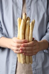 Woman with raw white asparagus spears, closeup