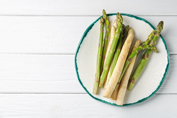 Different raw asparagus spears on white wooden table, top view. Space for text