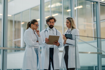 Medical team discussing patient chart in hospital corridor