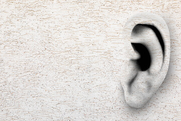 Human ear in white plaster wall, space for text. Eavesdropping, concept that even walls have ears