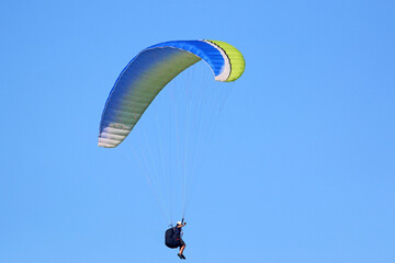 Paraglider flying in a blue sky	