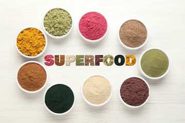 Superfood. Different powders in bowls on white wooden table, flat lay