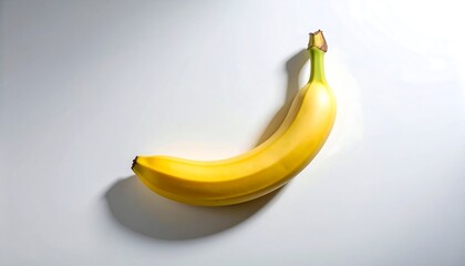 Single Banana Lying on a White Surface with Shadow