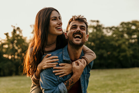 Happy couple laughing together outdoors in nature reserve