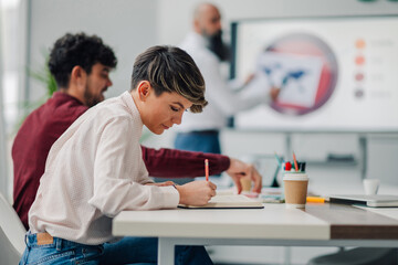 Creative businesswoman taking notes during a presentation in the office