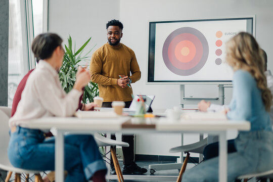Marketing manager leading presentation during team meeting in office
