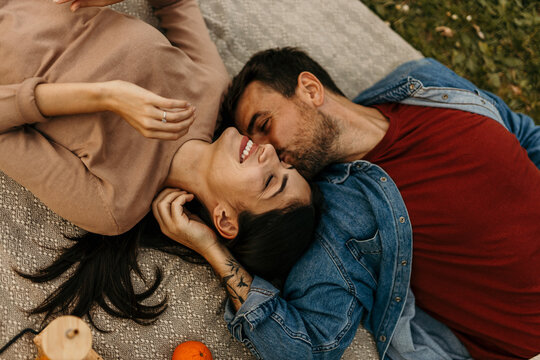 Happy couple lying on blanket enjoying romantic picnic outdoors