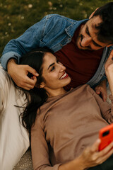 Couple relaxing outdoors using mobile phone