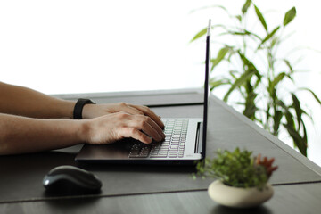 Close-Up of Hands Typing on Laptop Keyboard in Modern Workspace