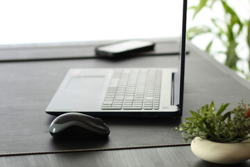 Open Laptop on Dark Desk Against Clean White Background