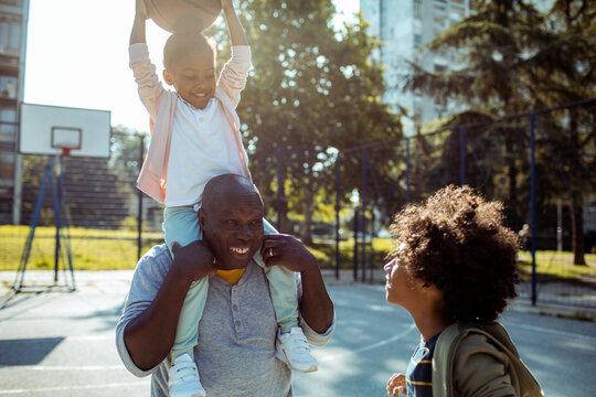 Family playing basketball together on outdoor court